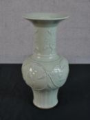 A Chinese celadon glazed porcelain vase, with a flared rim, a slender neck and a bulbous body,
