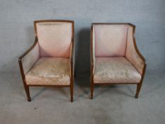 A pair of Edwardian mahogany and line inlaid armchairs, upholstered with pink damask, on tapering