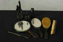 An early 20th century ebony part dressing table set comprising mirrors, brushes, glove stretchers