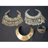 Three Tribal style torc necklaces with tassel decoration, set with glass cabochons and a similar