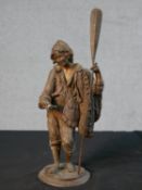 A late 19th / 20th century spelter figure of a fisherman holding a paddle and a fish raised on