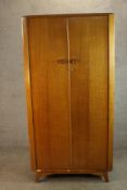 A 1960s Austinsuite teak wardrobe with a pair of doors, opening to reveal hanging space and