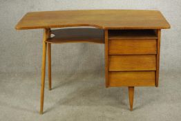 A mid 20th century French desk with bank of three graduating drawers raised on tapering supports.