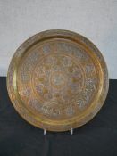A Middle Eastern circular copper tray, with engraved decoration, with silver mounted vines and