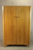 A 1960's Austinsuite teak wardrobe with a pair of doors, opening to reveal hanging space and