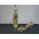 A carved and painted Javanese Wayang shadow puppet doll in silk clothing along with another Javanese