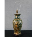 A Chinese porcelain table lamp; with all over gild painted scroll decoration on green ground; raised