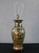 A Chinese porcelain table lamp; with all over gild painted scroll decoration on green ground; raised