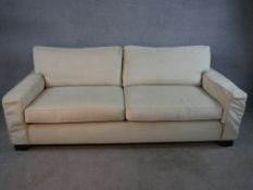 A contemporary Kingcome two seater cream upholstered sofa raised on block feet. H.84 W.120 D.100cm.