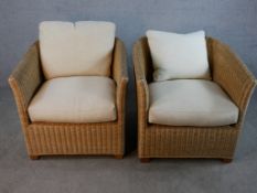 Pair of contemporary wicker conservatory chairs with loose fitted cushions raised on block feet, H.