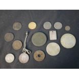 A collection of world coins, and a Chinese rectangular plaque with characters.