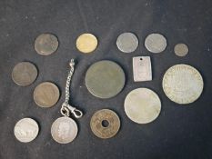 A collection of world coins, and a Chinese rectangular plaque with characters.