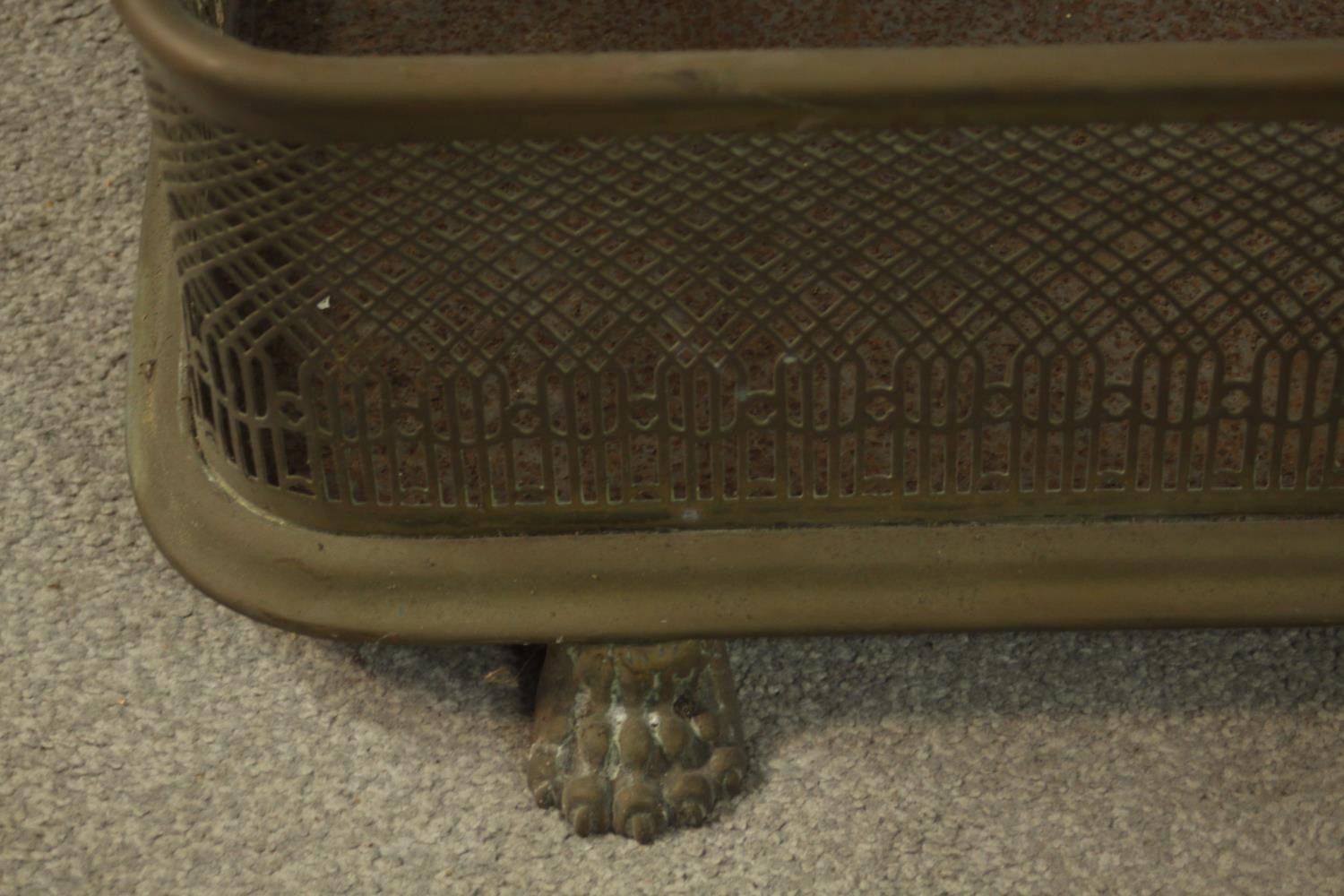 A late 19th century pierced brass fender raised on lion law feet. H.19 W.127 D.34cm. - Image 5 of 5