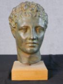 A replica bronze effect plaster Roman style head of a man, raised on wooden plinth H.29 W.13 D.13cm