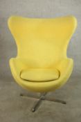 After Arne Jacobsen, a yellow upholstered Egg style chair raised on four chrome plated splayed base.