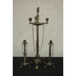 Three Victorian brass candle holders, a pair and a larger three branch candelabra with flame