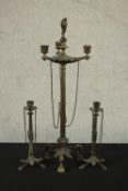 Three Victorian brass candle holders, a pair and a larger three branch candelabra with flame