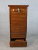 A late Victorian walnut tambour fronted filing cabinet, fitted with shelves, on a plinth base. H.116