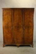 An early 20th century walnut gentlemen's wardrobe, the left door opening to reveal hanging space and