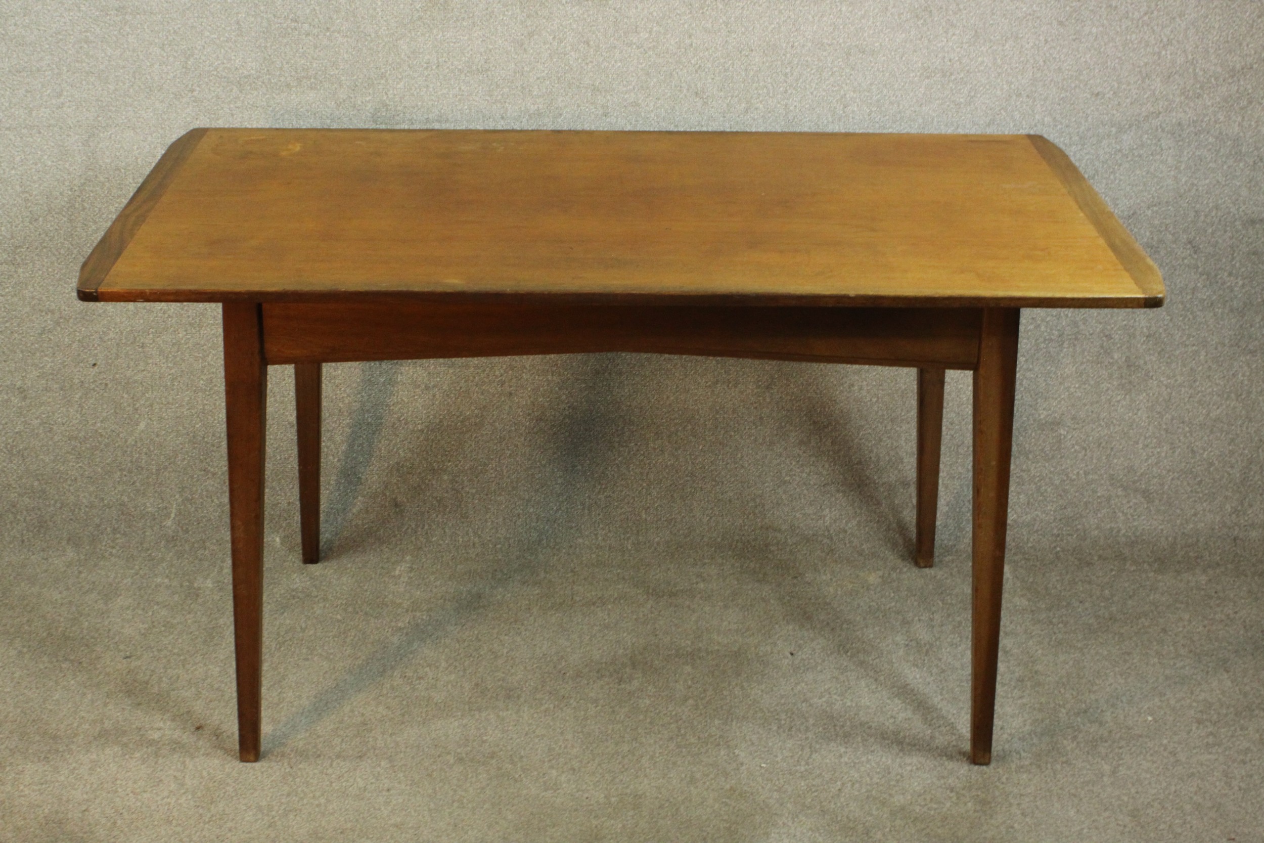 A circa 1960's teak dining table by Storys of Kensington, the rectangular top with cleated ends,