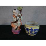 Chinese porcelain figure of a child holding a ruyi sceptre; together with a Chinese yellow pottery