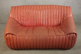 A mid to late 20th century pink leather Roset of France two seater settee with vertical stitching
