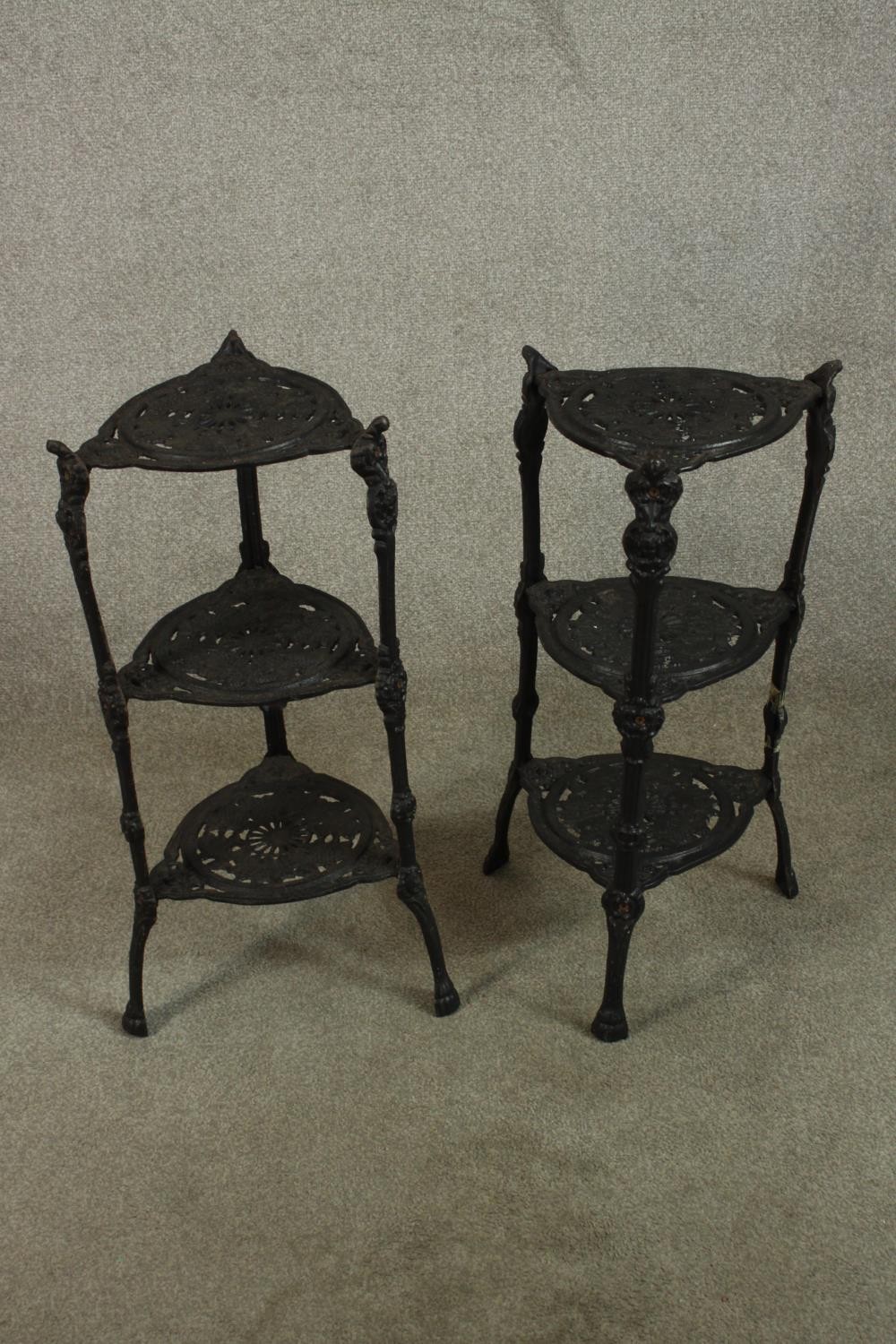 A pair of painted Victorin style pierced iron three tier saucepan holders raised on outswept