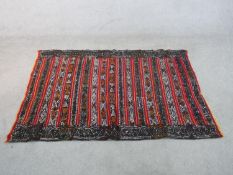 A 20th century red ground Eastern Kelim with stripes of geometric pattern in various colours L.165