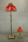 An early 20th century reeded brass standard lamp with red silk shade on stepped onyx base