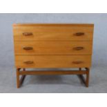 Ernst Gomme for G-Plan, a 1970s teak chest, with three long drawers, the end supports joined by a
