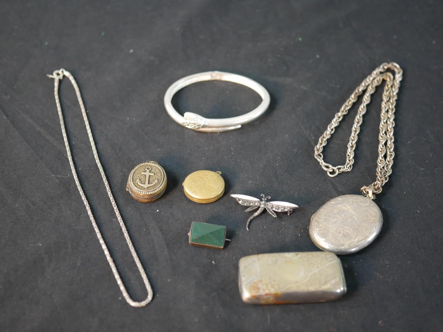 A collection of silver and jewellery, including a silver oval locket and chain, a silver,