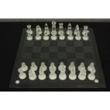 A contemporary frosted and clear glass chess set complete with chess board. H.8 W.38 D.38cm.