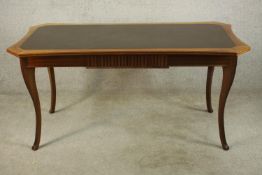 A late 19th / early 20th century, possibly French mahogany and leather inset shaped canted top