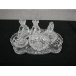 An Art Deco cut glass dressing table set, including a pair of candlesticks, ring holder, lidded