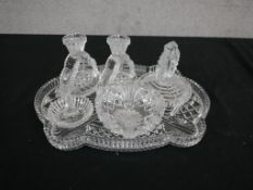 An Art Deco cut glass dressing table set, including a pair of candlesticks, ring holder, lidded