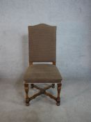A set of four hump back dining chairs, upholstered in brown fabric to the back and seat, raised on