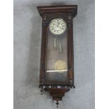 A late 19th / early 20th century oak cased regualator style wall clock, the white dial with black