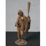 A late 19th / 20th century spelter figure of a fisherman holding a paddle and a fish raised on