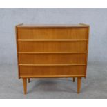A circa 1960s teak chest of four long drawers, on cylindrical tapering legs. H.64 W.60 D.33cm