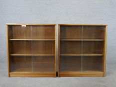 A pair of circa 1970s Jonell bookcases, with a pair of glass sliding doors enclosing shelves, on a
