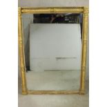 A 19th century Italian style gilt framed wall mirror with rope twist column and carved rounde