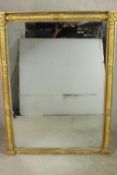 A 19th century Italian style gilt framed wall mirror with rope twist column and carved rounde