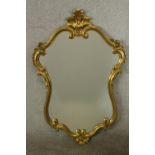 A 19th / early 20th century gilt framed cartouche shaped wall mirror. H.100 W.65cm.