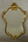 A 19th / early 20th century gilt framed cartouche shaped wall mirror. H.100 W.65cm.