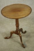 A George III mahogany wine table with turned central column on three outswept supports on pad