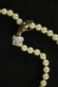 A faux pearl necklace and bracelet with silver clip clasp in the form of a ladies hand, paste set