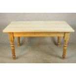 An early 20th century stripped pine kitchen table raised on turned legs. H.77 W.153 D.85cm.