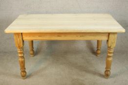 An early 20th century stripped pine kitchen table raised on turned legs. H.77 W.153 D.85cm.