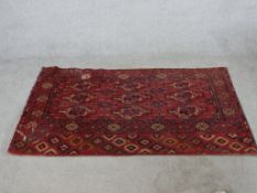 A 19th / 20th century red ground Bokhard rug with central lozenge design within geometric border.