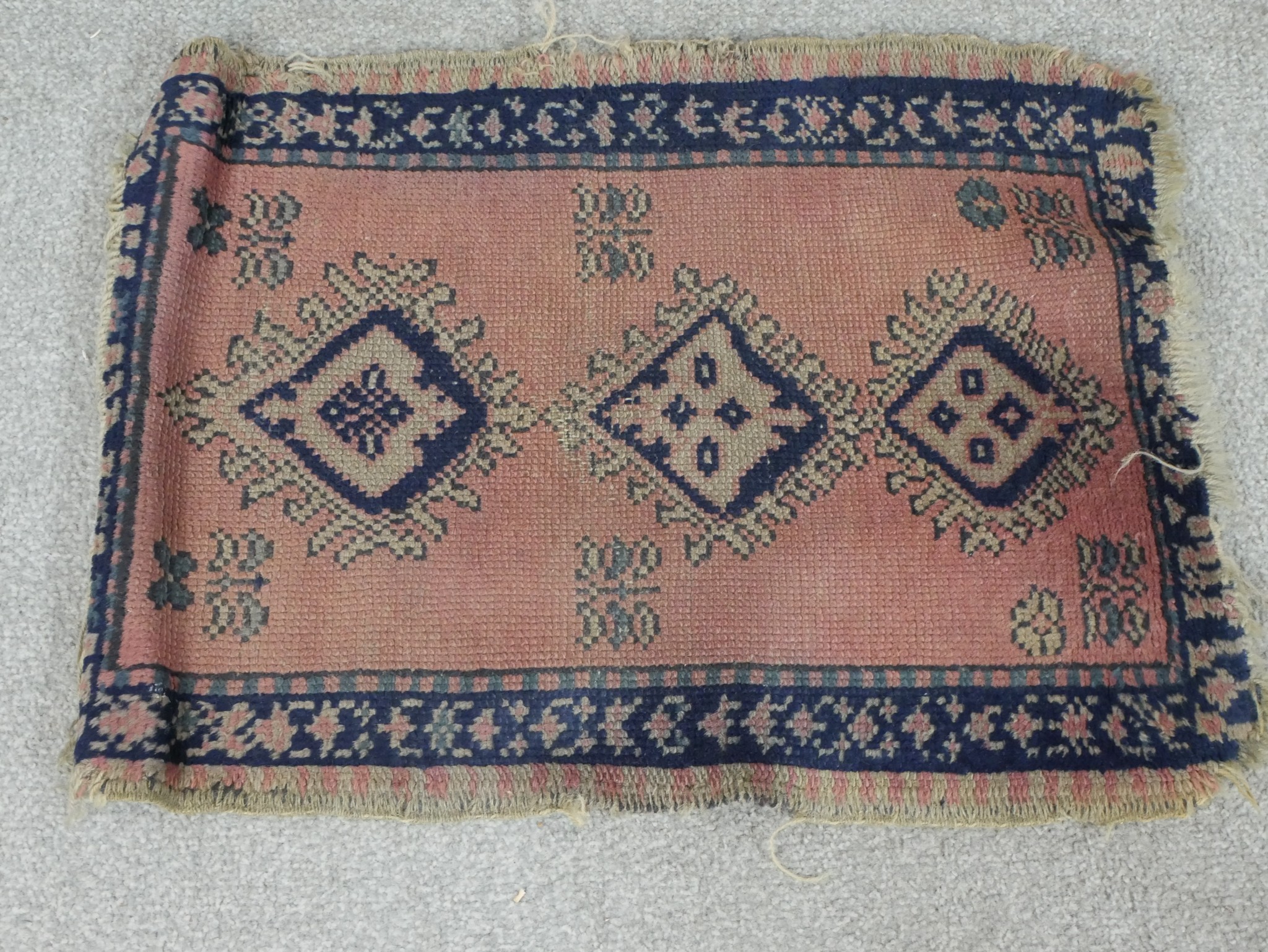 A 20th century Afghan Kazak style blue, pink and green rug with three central lozenges, . L.46 W.